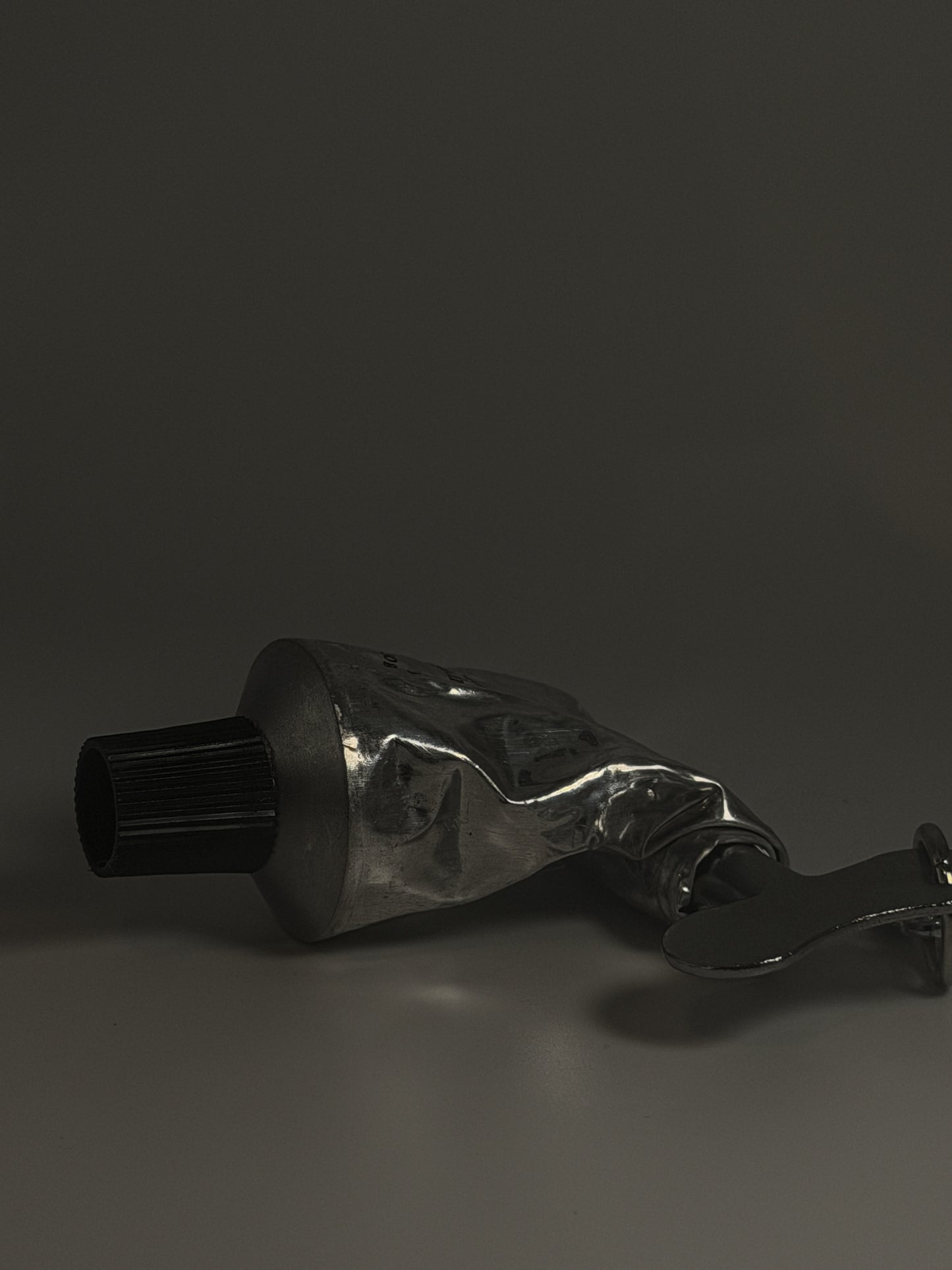 Metallic tube with a nozzle on a dark background