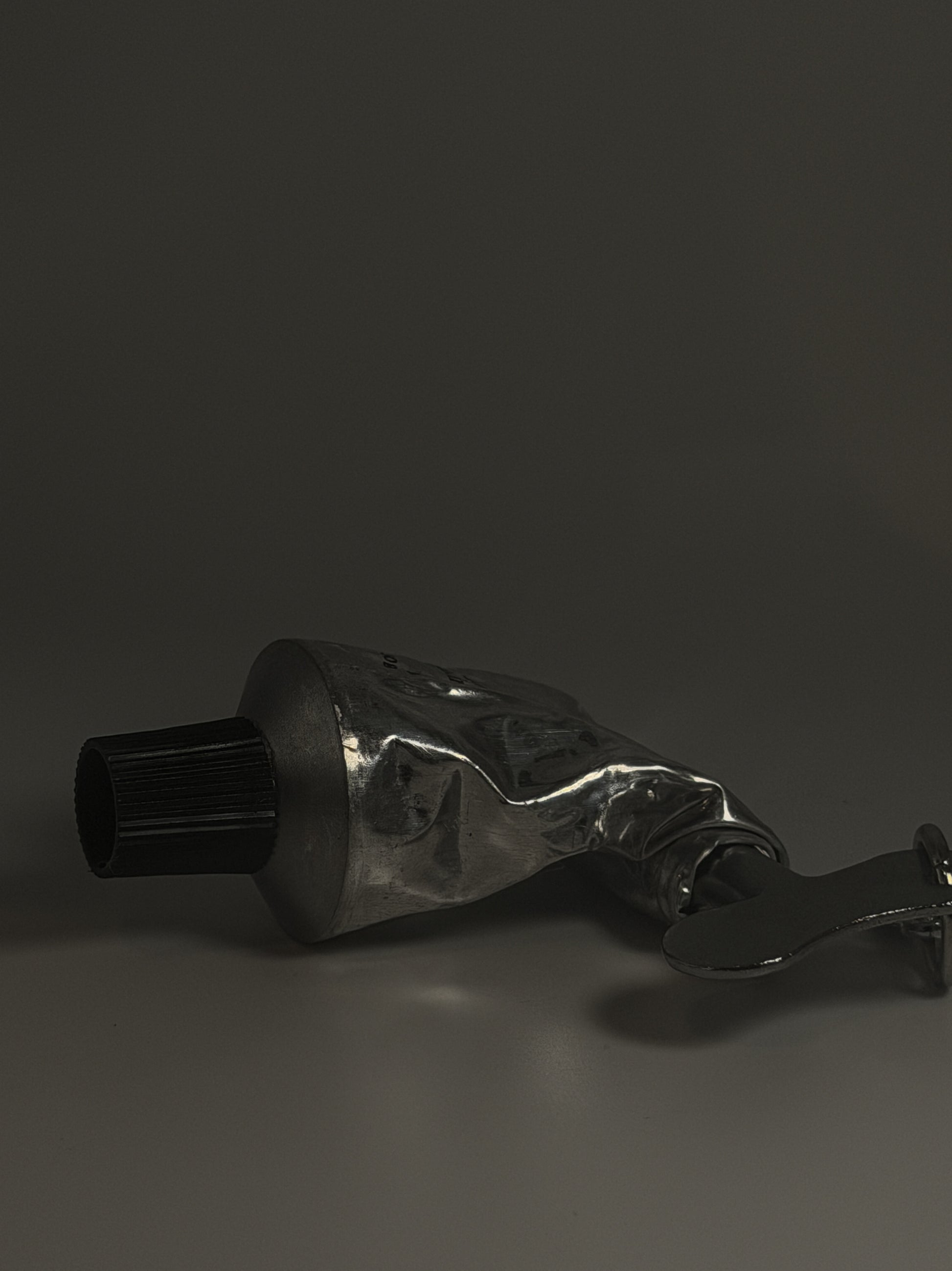 Metallic tube with a nozzle on a dark background