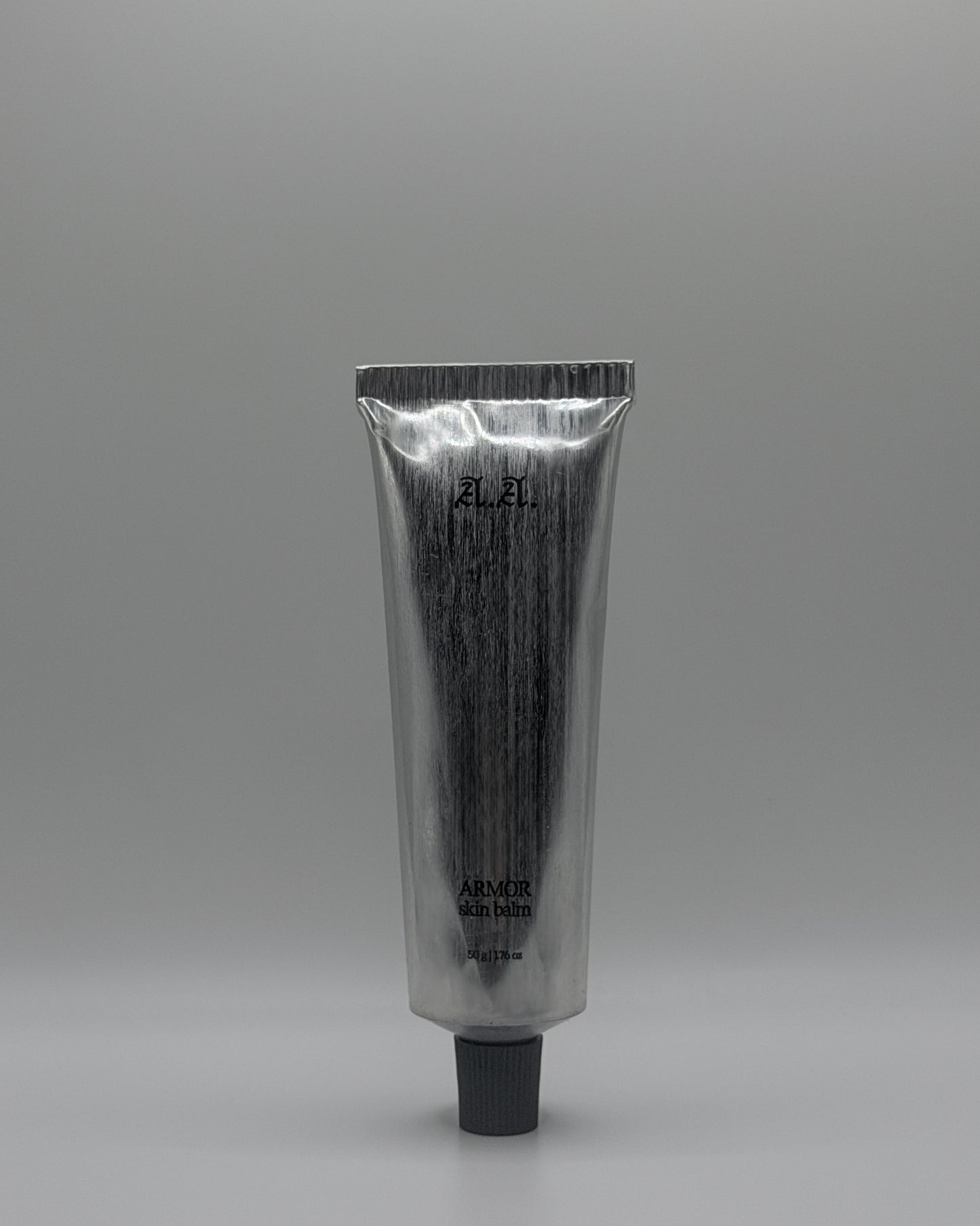 Silver tube with black cap on a gray background